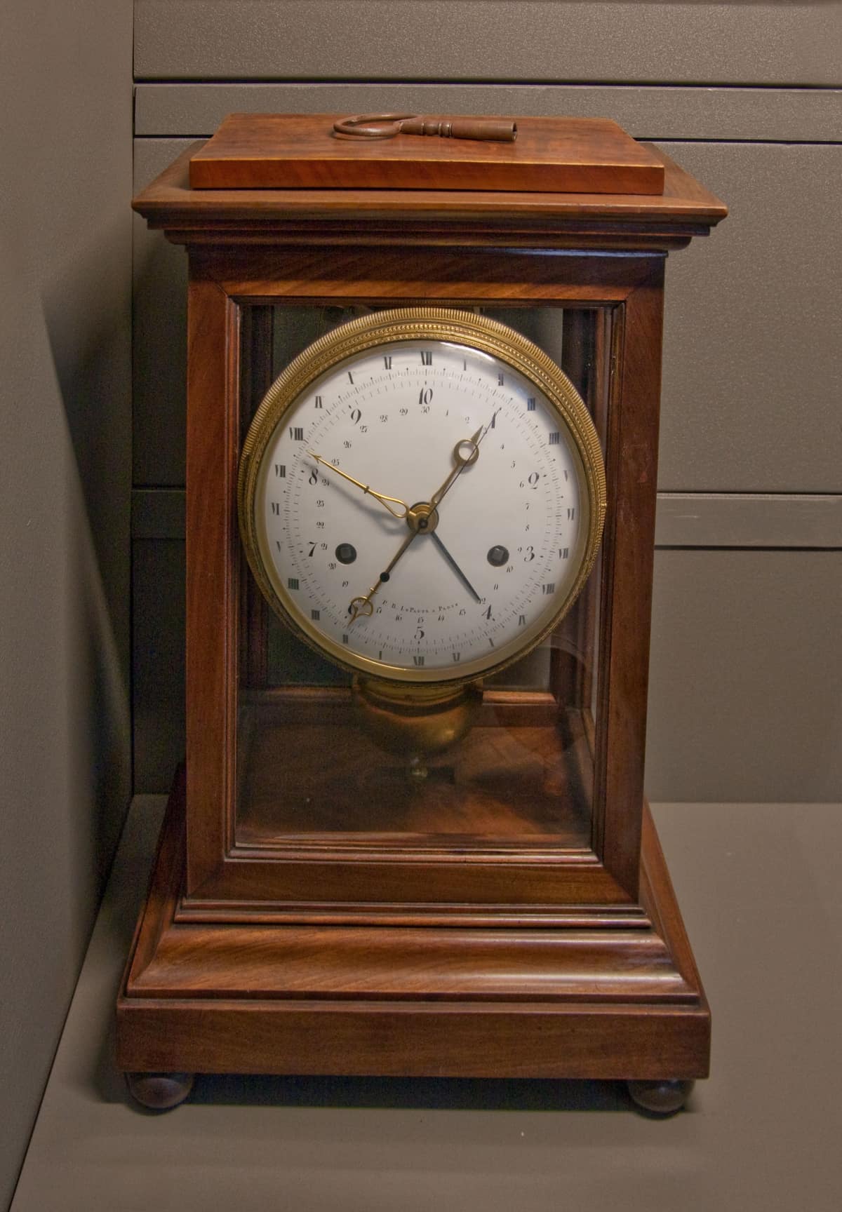 Reloj histórico de 1795 con esfera metálica que combina diez horas decimales y números romanos para la hora tradicional.