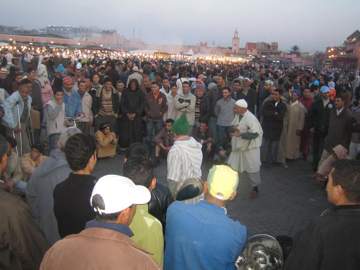 Círculo de espectadores alrededor de narradores en Jemaa el-Fna, Marrakech.