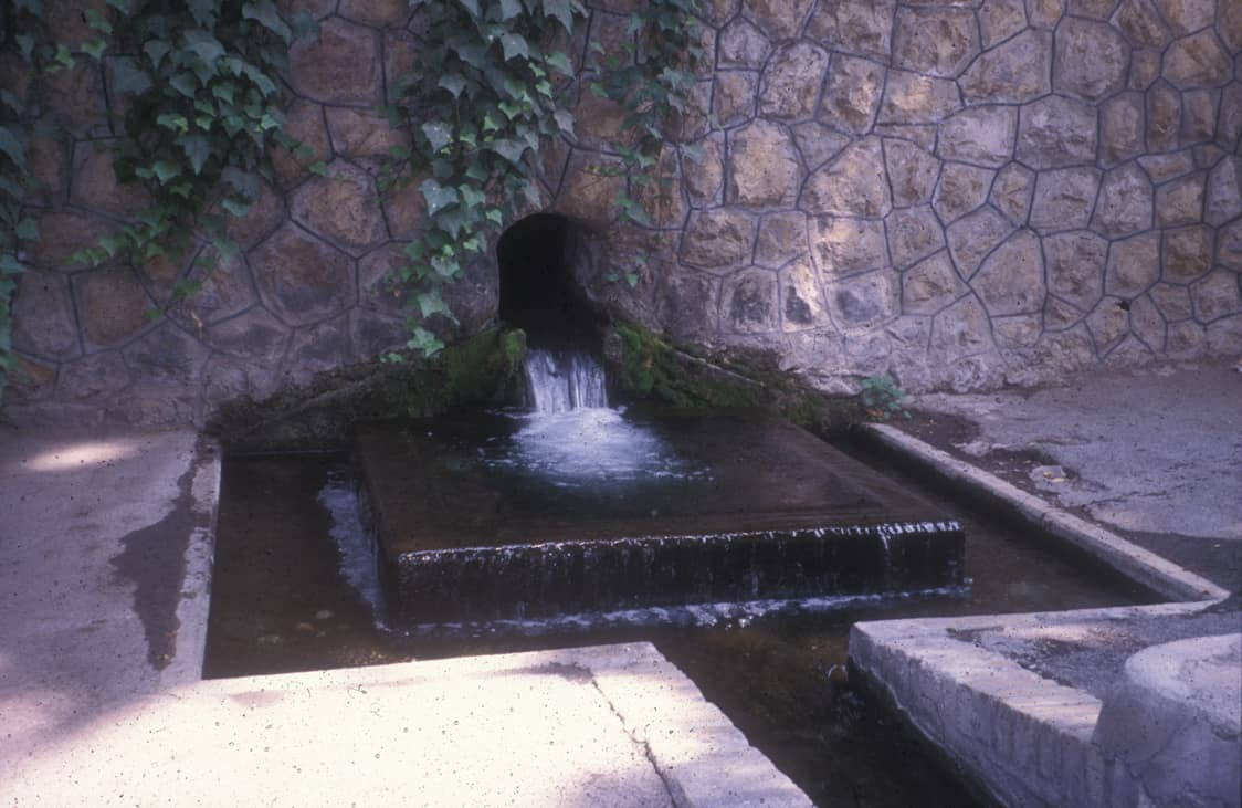 Entrada de piedra a un qanat en Niavaran, Irán, con la abertura hacia la conducción subterránea de agua.