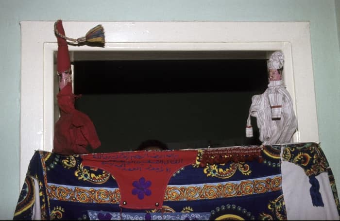 Titiritero egipcio manipulando a Al-Aragoz durante una representación en una casa.