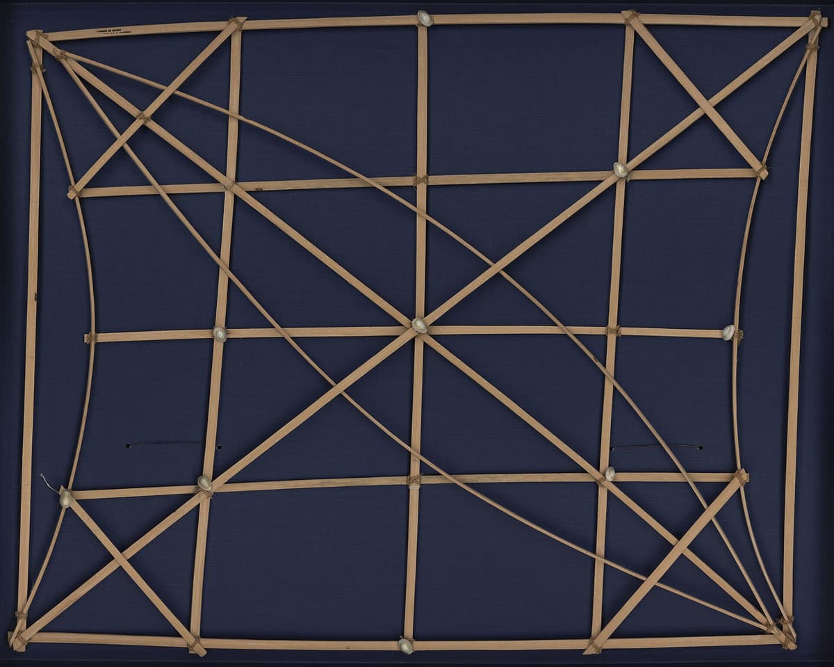 Carta marshalense de varillas curvas y conchas montada dentro de una caja.